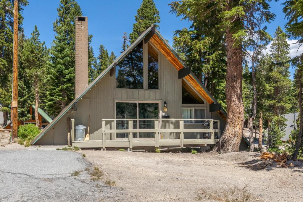 a house in the woods with a tree at Chalet 15 by Mammoth Mountain Chalets in Mammoth Lakes