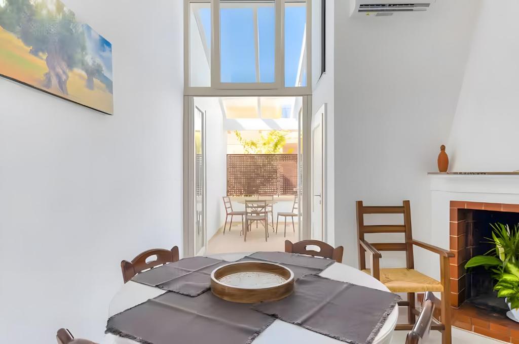a dining room with a table and a fireplace at Casa Don Paolo in Alessano