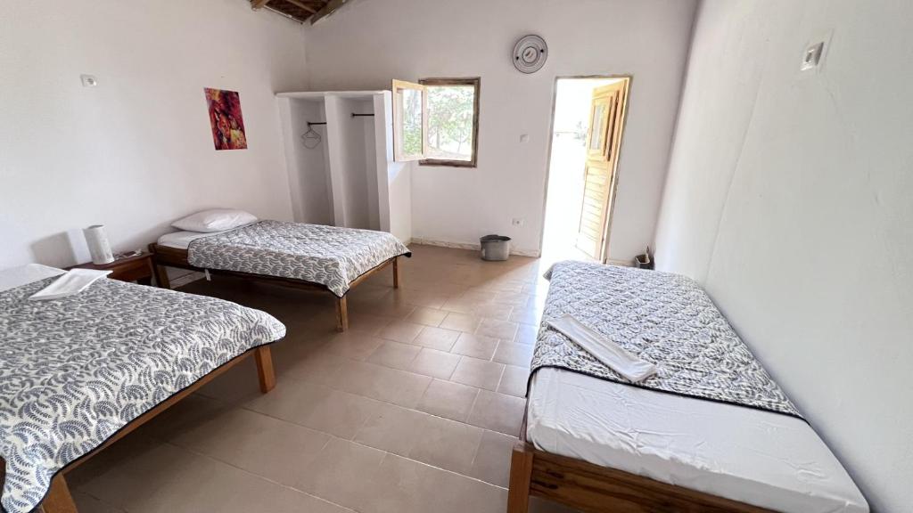 a room with two beds and a window at Vacaciones Timonier in Ndangane