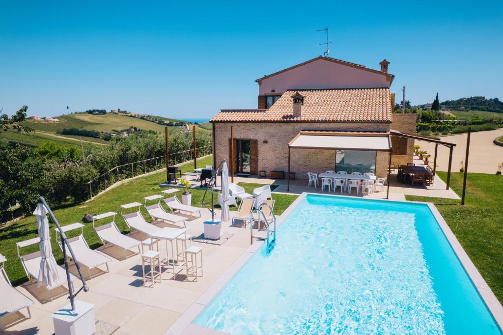 a villa with a swimming pool in front of a house at Italian Experience-Villa Clair in Fermo