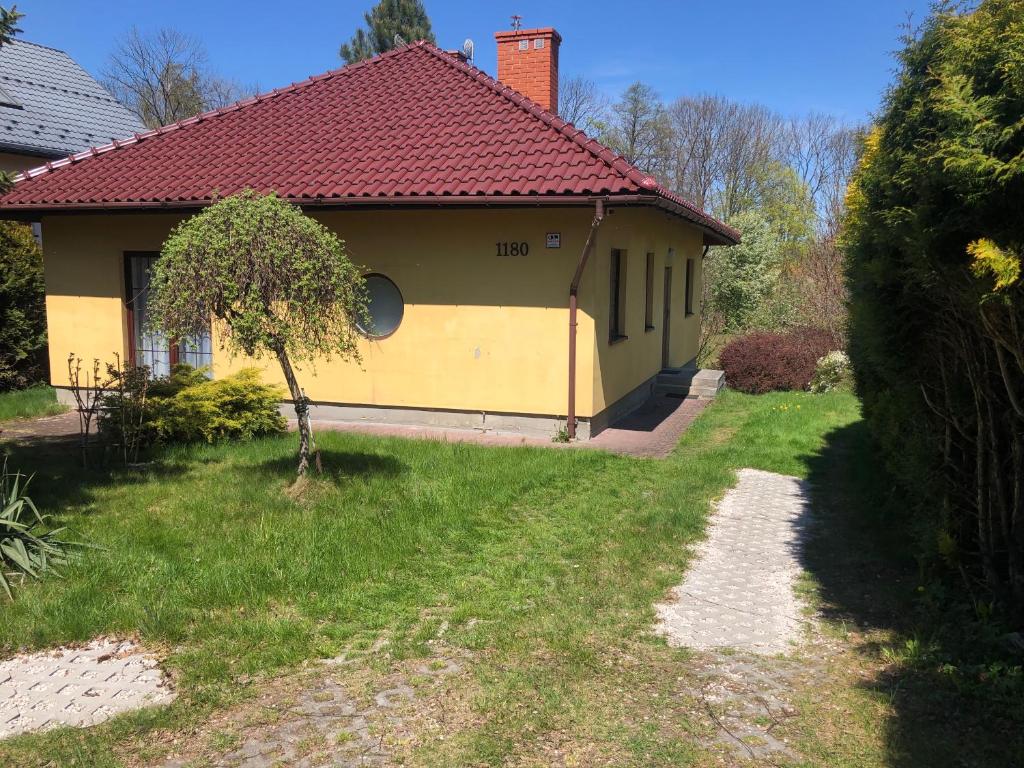 a yellow house with a red roof at Apartament Zielone Buki in Buczkowice