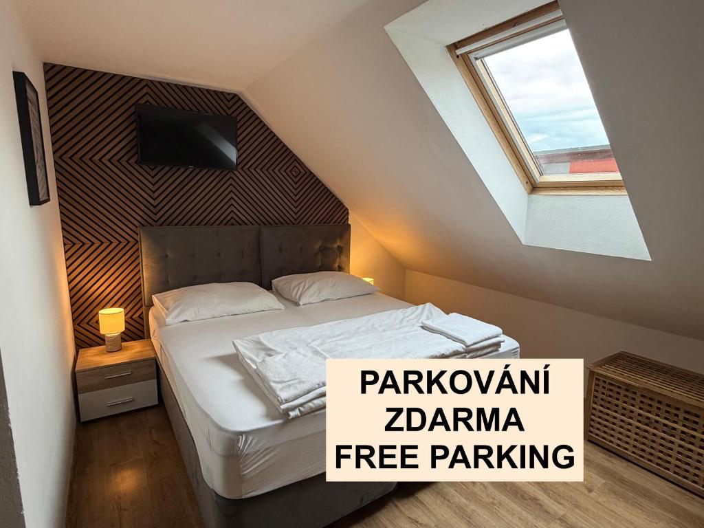 a bedroom with a bed in a attic with a window at Slavia penzion in Mikulov