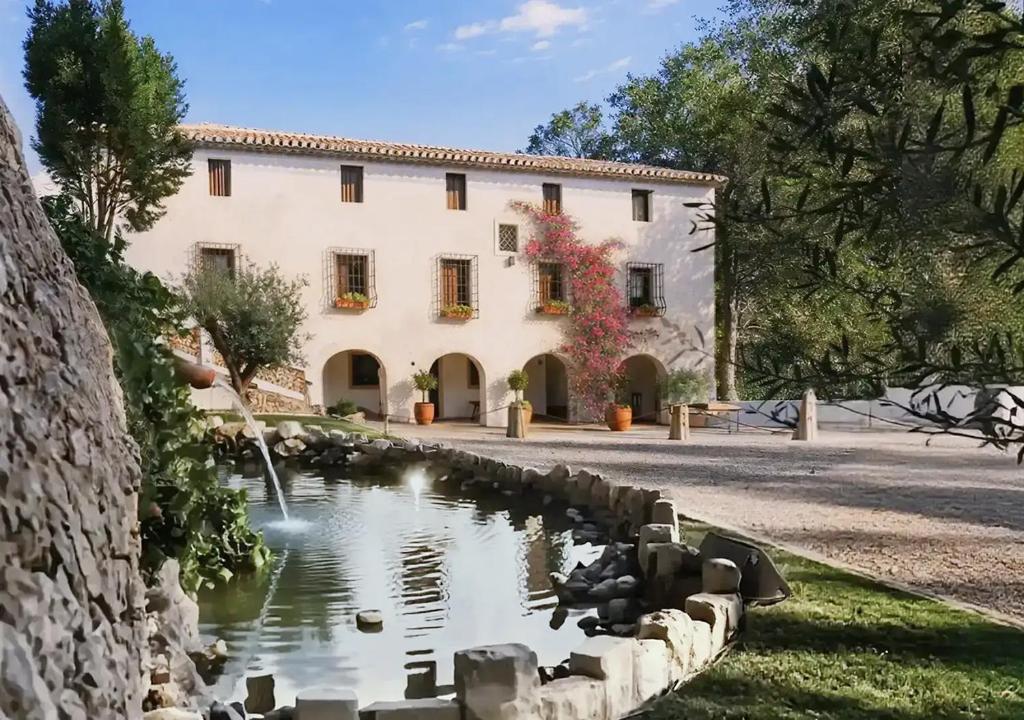 a large building with a pond in front of it at Hotel Masía de Altea in Altea