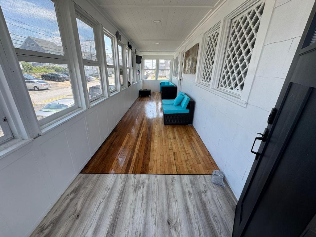 a hallway with a blue couch in a room with windows at Sun2Sand Beach House in Salisbury