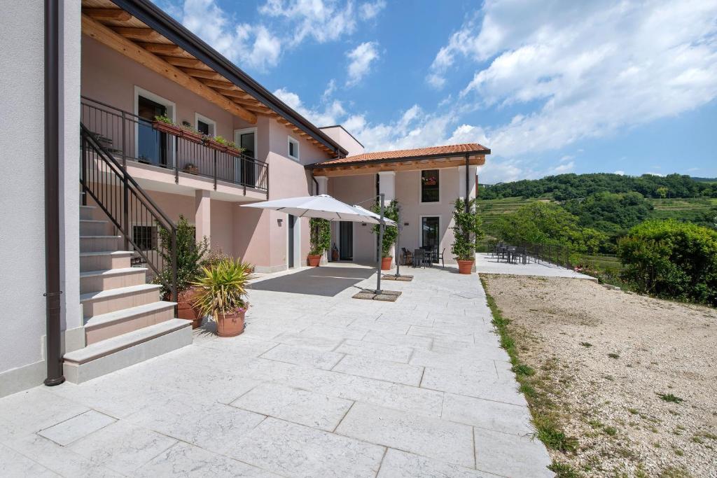 a house with a patio and an umbrella at Agriturismo Cascina Capo in Negrar