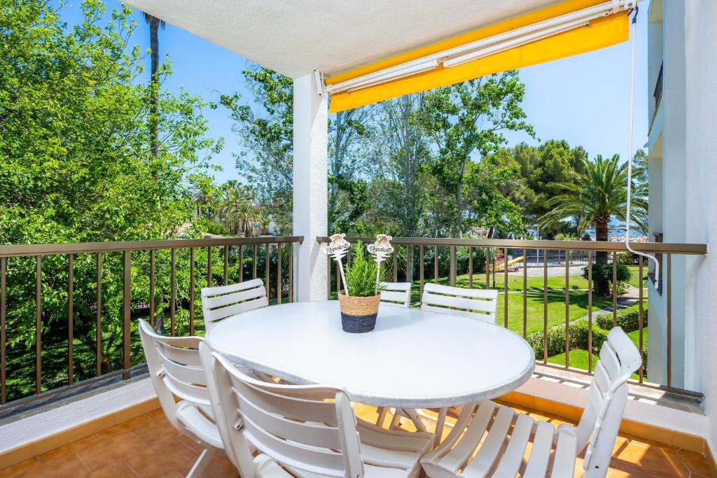 a white table and chairs on a balcony with a window at Ana Playasol in Port d'Alcudia