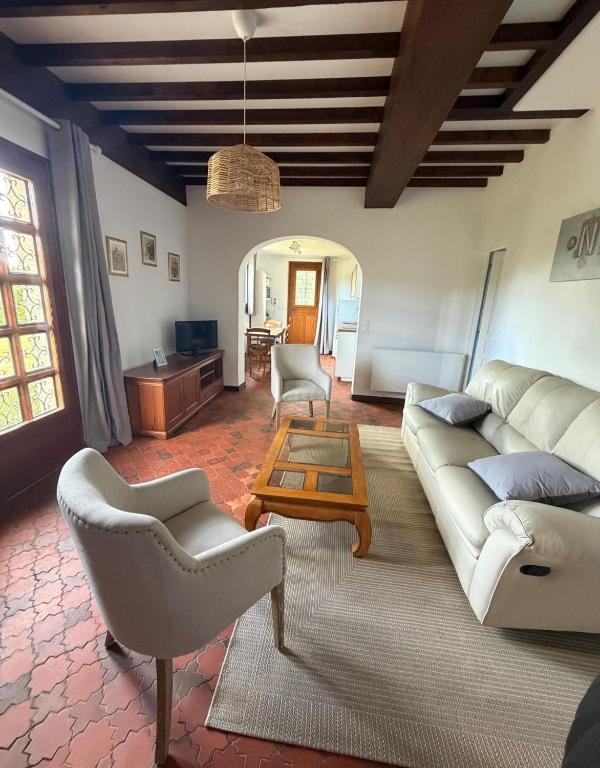 a living room with a couch and chairs and a table at Au cerisier in Saint-Maulvis