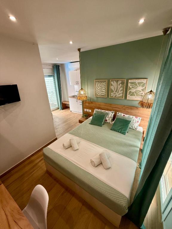 a bedroom with two beds with green walls at ΑVLI Sarti Superior Studio no5 in Sarti