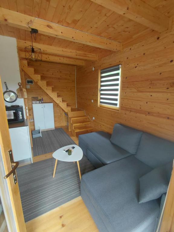 a living room with a blue couch and a table at A-frame Đukić in Jajce