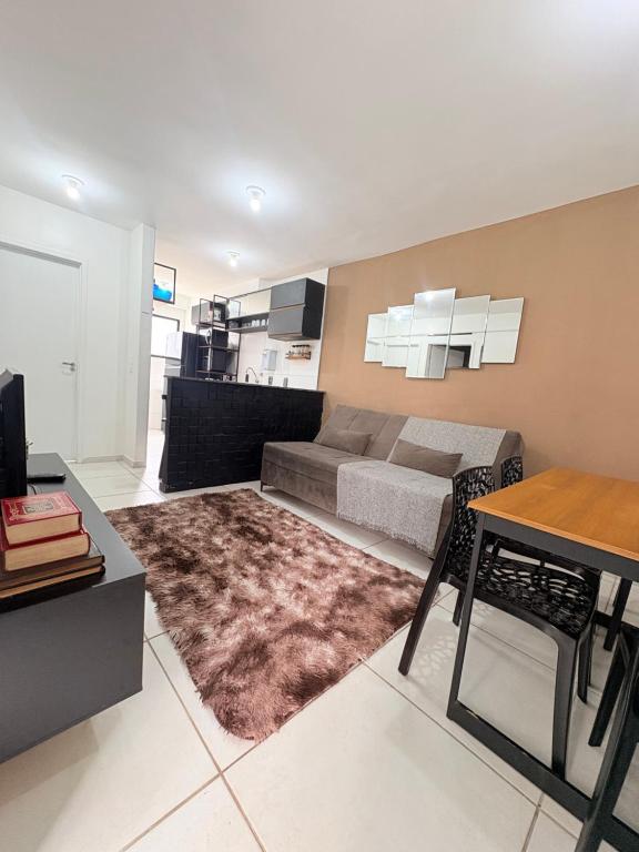 a living room with a couch and a table at Apê moderno perto do shopping - WI-FI rápido e garagem in Caruaru