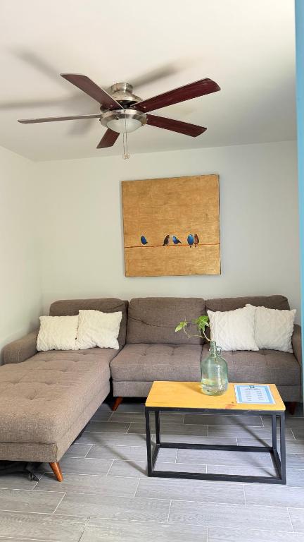 a living room with a couch and a ceiling fan at Loft-LunaRoja in Montemorelos