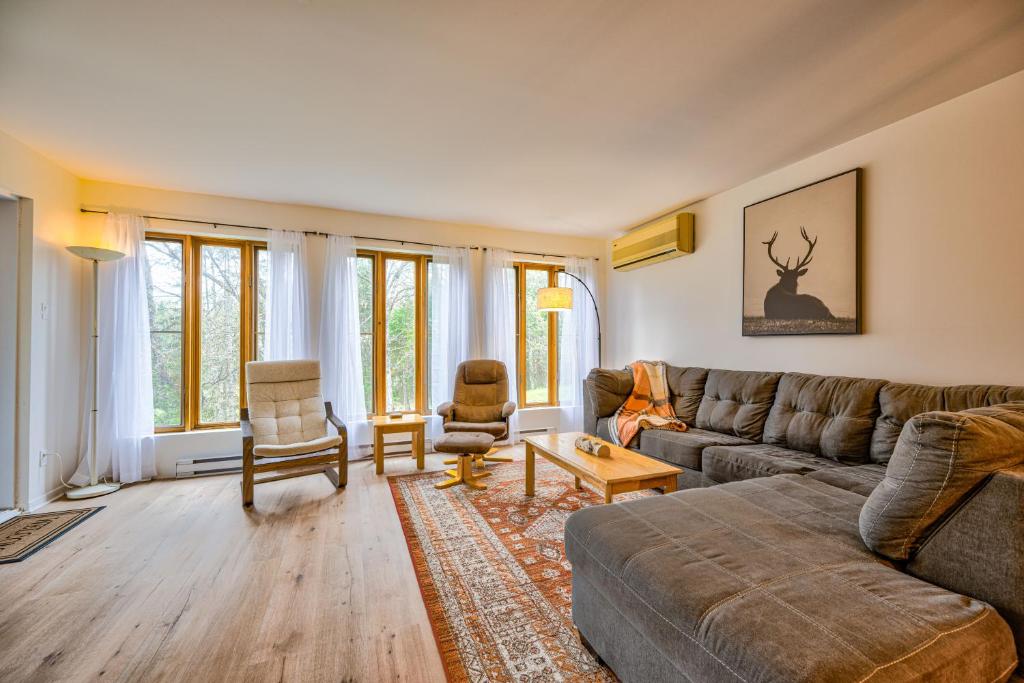 a living room with a couch and chairs and windows at Le Summit in Mont-Tremblant