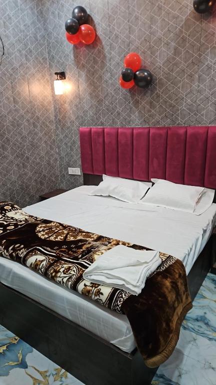 a bed with a red headboard in a room at Agrawal seva sadan in Mathura