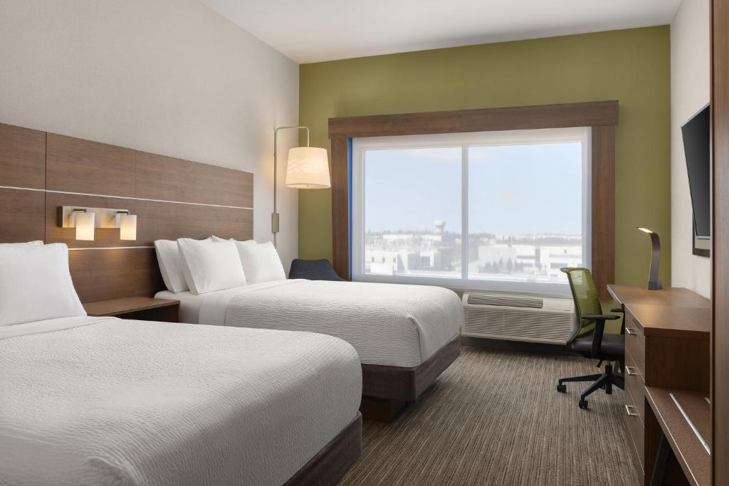 a hotel room with two beds and a desk and a window at Holiday Inn Express & Suites - Aurora by IHG in Aurora