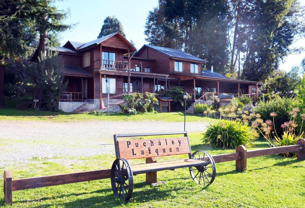 a sign in the grass in front of a house at Apart hotel Puchaley Lafquen in Panguipulli