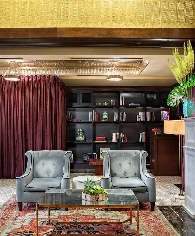 a living room with two chairs and a coffee table at Walker Hotel Greenwich Village in New York