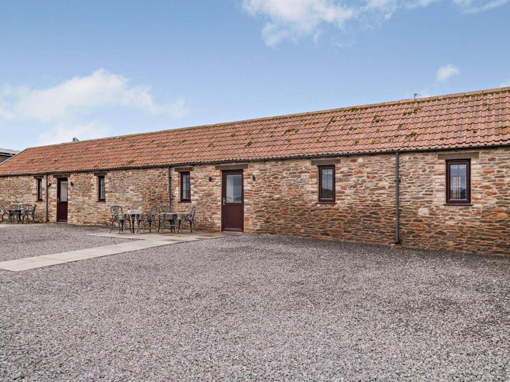 a brick building with tables and chairs in front of it at 2 Bed in Bristol oc-72837 in Chew Magna