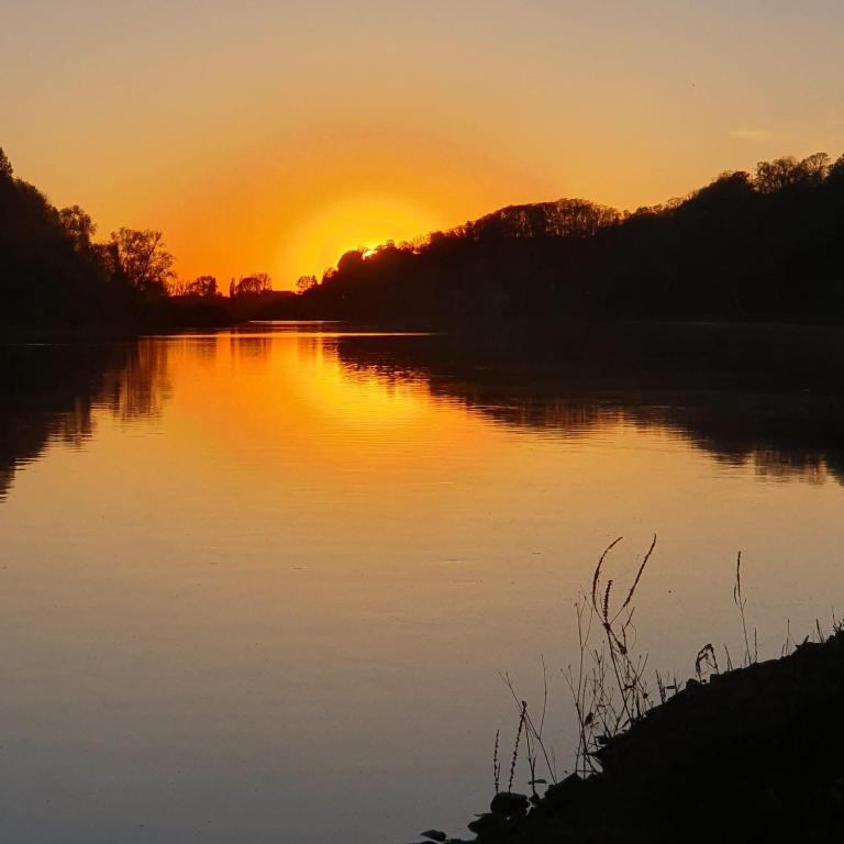 a sunset over a lake with the sun setting at Ferienhaus zum Eiskeller in Stadt Wehlen