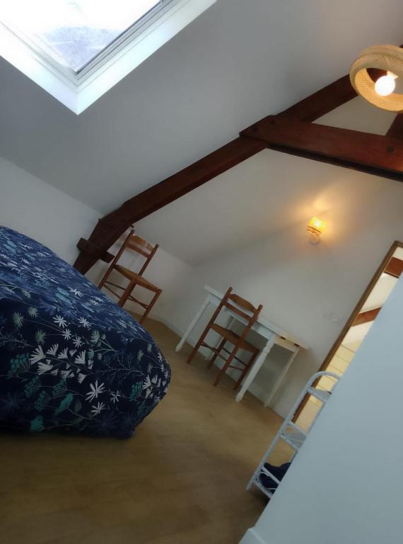 a room with a bed and a table and chairs at Gîte entre l'océan et le golfe in Surzur