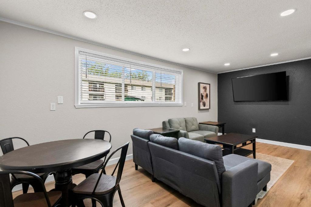 a living room with a table and a tv at Newly Renovated Unit in Central Spfld #103 in Springfield