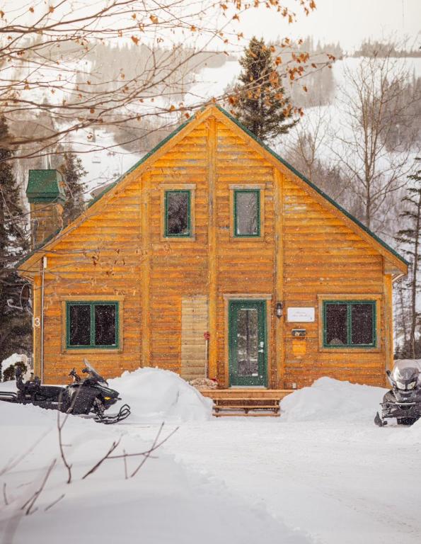 a large wooden house in the snow at Chalets Gallix in Sept-Îles