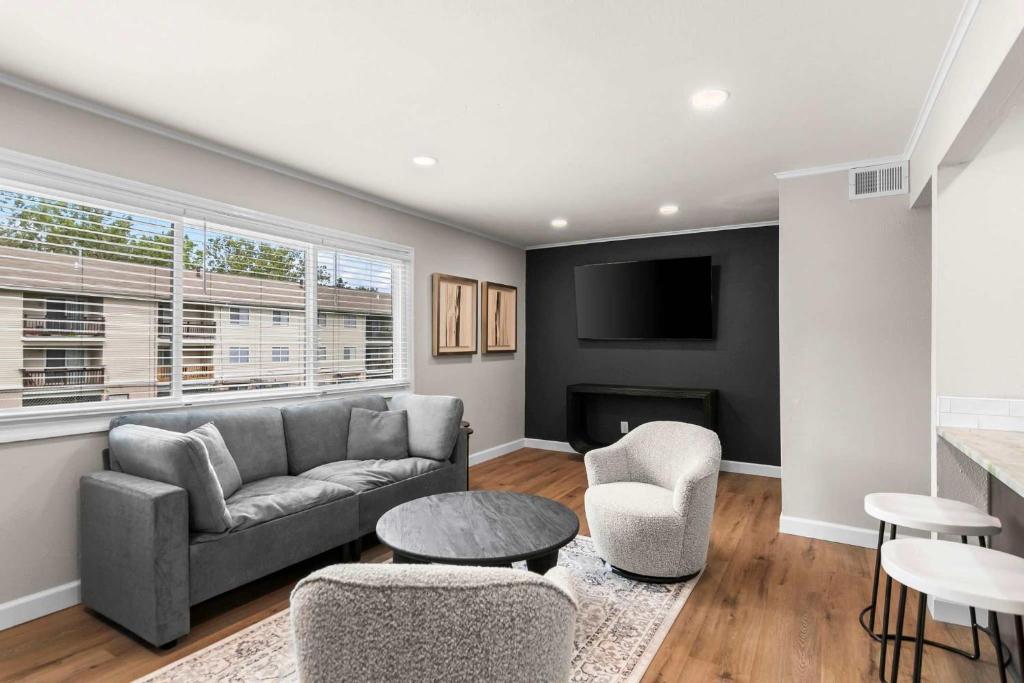 a living room with a couch and a tv at Newly Renovated Unit in Central Spfld #203 in Springfield