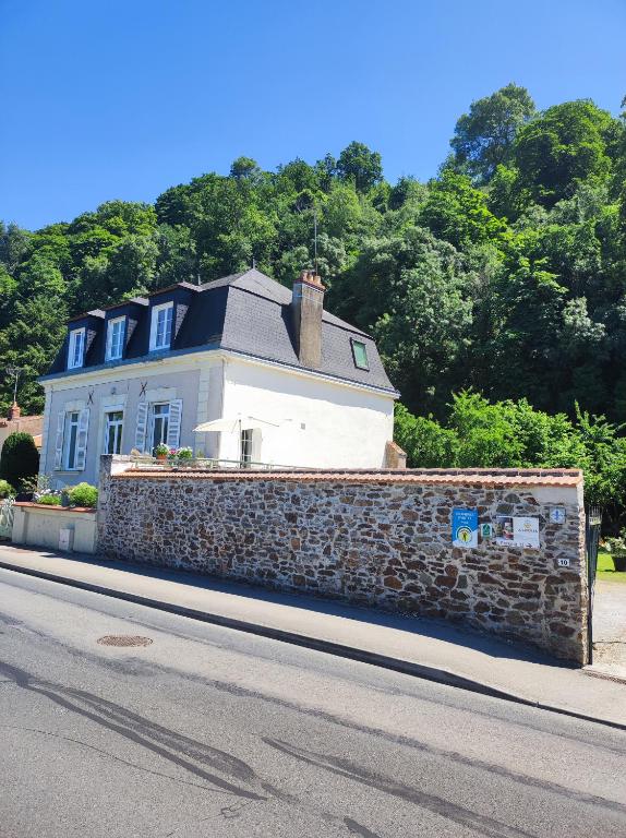 a house behind a stone wall on the side of a street at Lucriolla in Champtoceaux