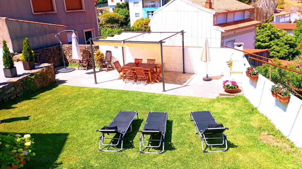 a yard with chairs and a table and a table and chairs at Casa Mamalola in O Grove