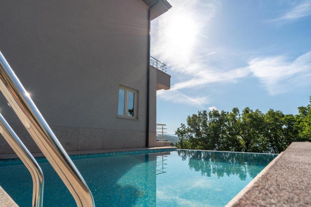 a swimming pool in front of a house at Villa Manuela in Opatija
