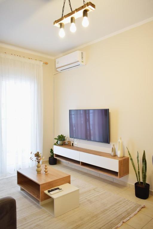 a living room with a large flat screen tv at Emmeleia Urban Apartment in Xanthi