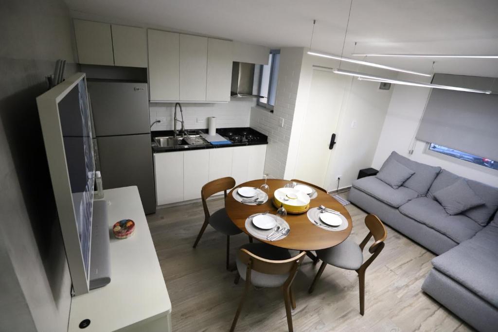 a kitchen and a dining room with a table and a couch at Departamento en el corazón de angelópolis in Puebla