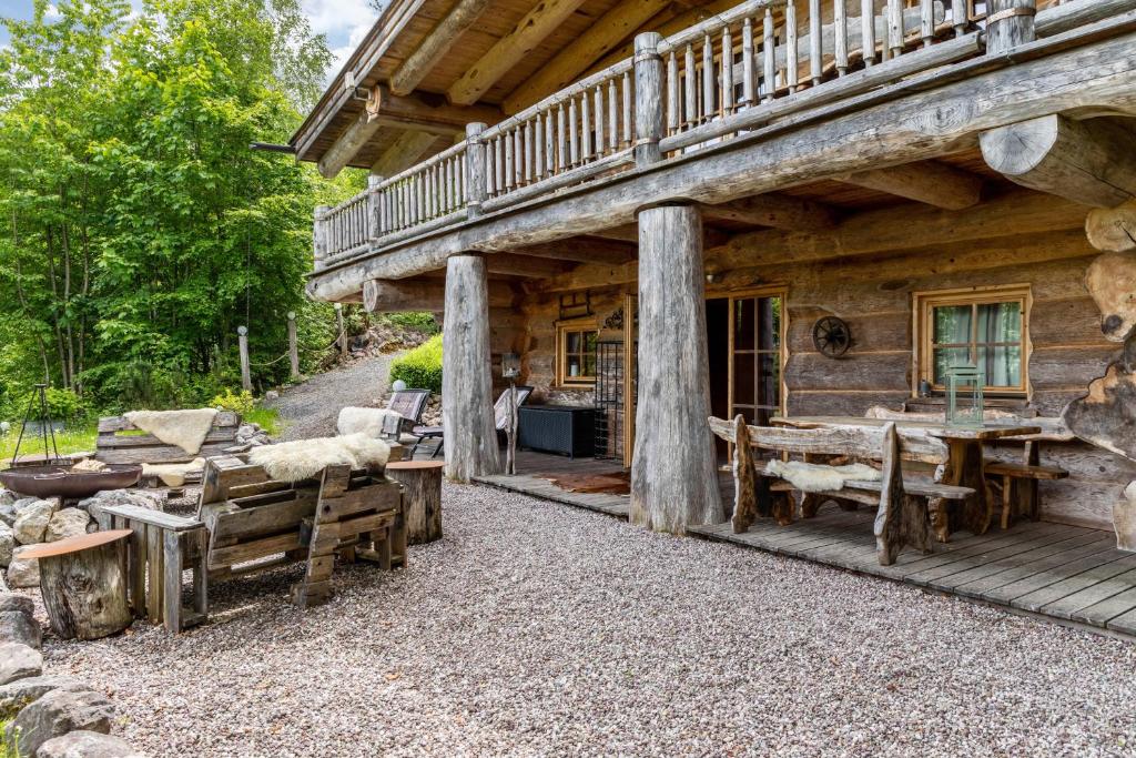a log cabin with a porch and tables and chairs at Chalet Weiss in Wörgl