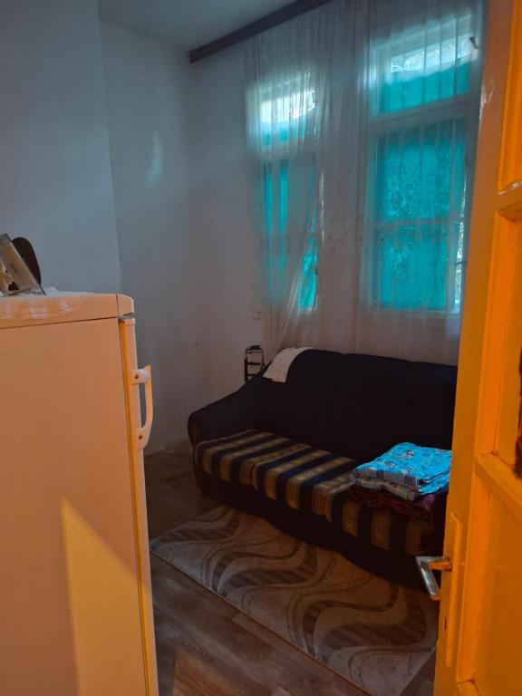 a couch sitting in a room with a window at Anita in Danilovgrad
