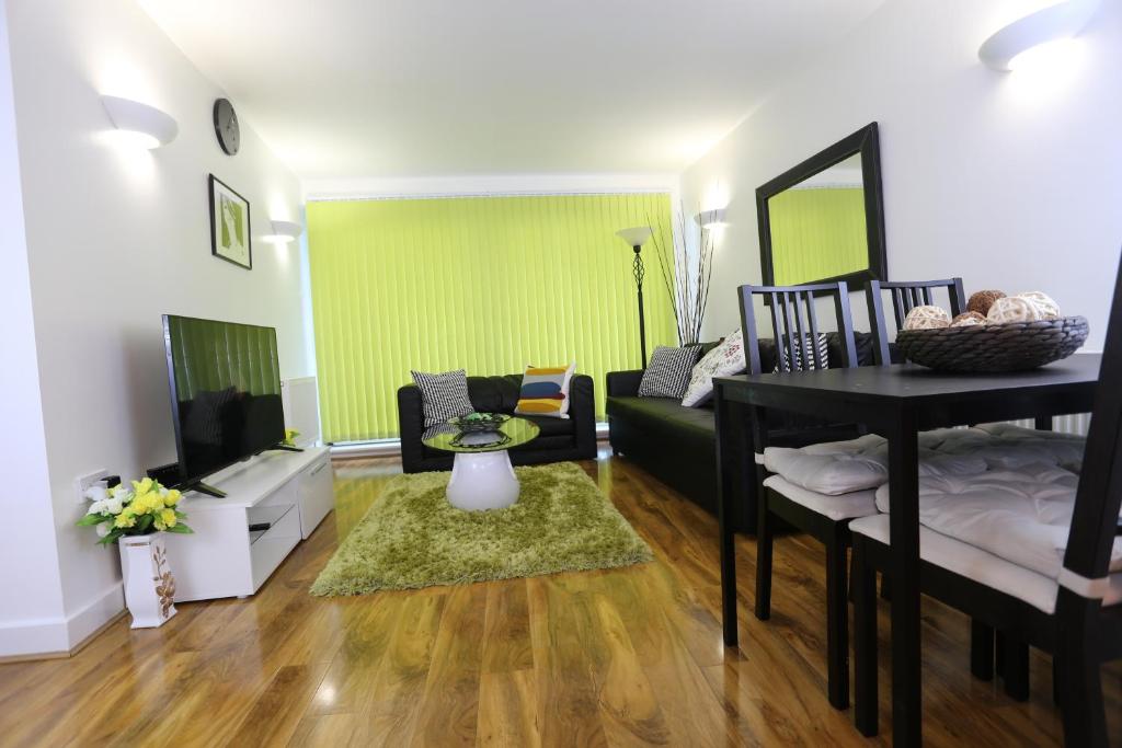 a living room with a couch and a tv at Tideslea Riverview Apartment in Plumstead