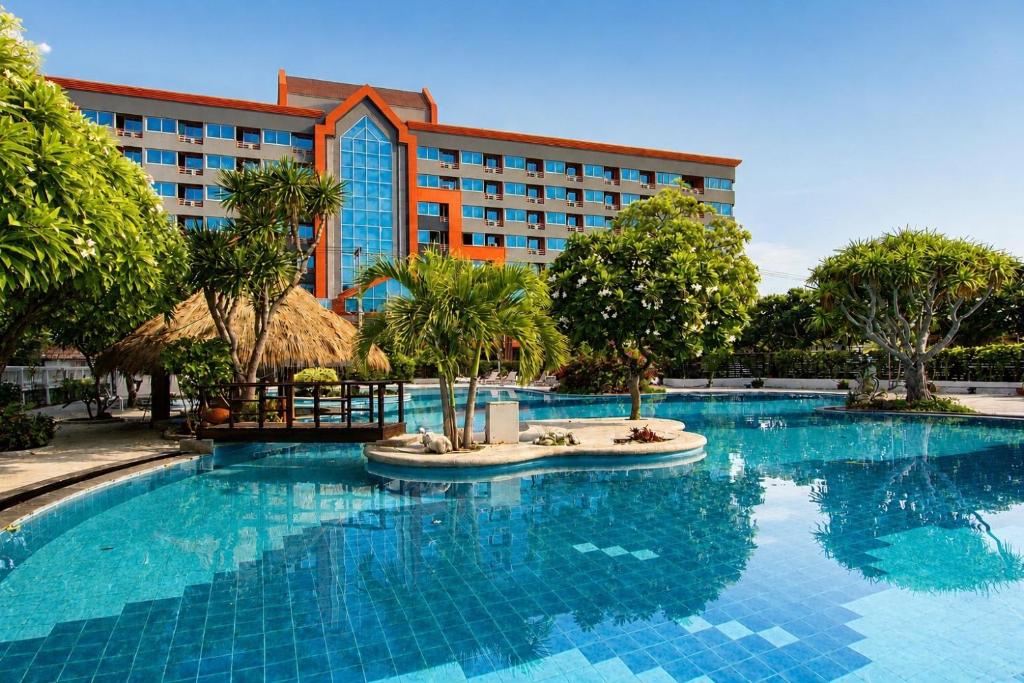 a large swimming pool in front of a hotel at Coco Beach Hotel Jomtien Pattaya in Jomtien Beach
