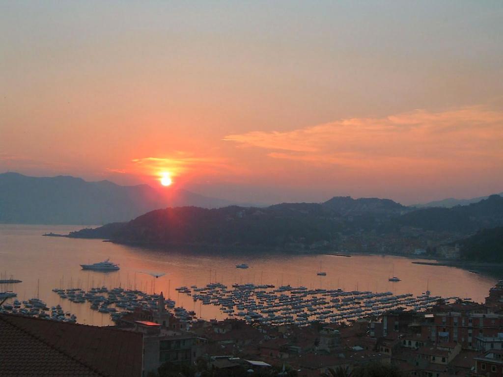 a sunset over a large body of water with boats at HOTIDAY Apartment Collection - Lerici Terrediliguria in Lerici