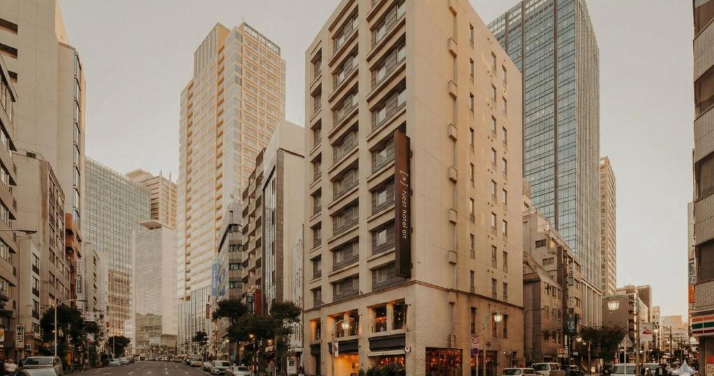a tall building in a city with tall buildings at Nesthotel Alt Meguro Ekimae in Tokyo
