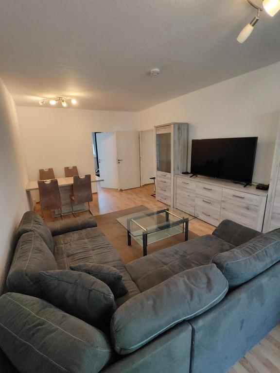 a living room with a large couch and a flat screen tv at Monteurwohnungen Bad Langensalza in Bad Langensalza
