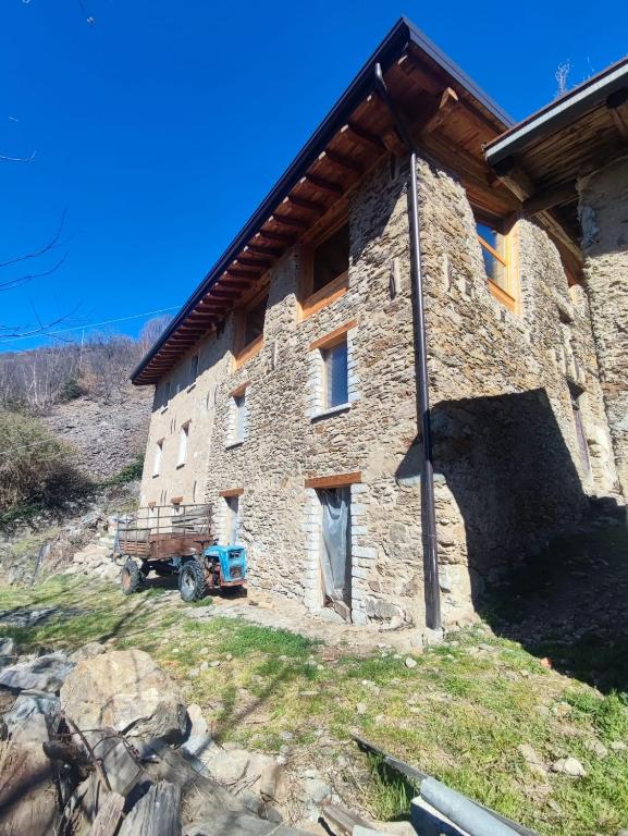 a large stone building with a wooden roof at La Baita nel Bosco in Berzo