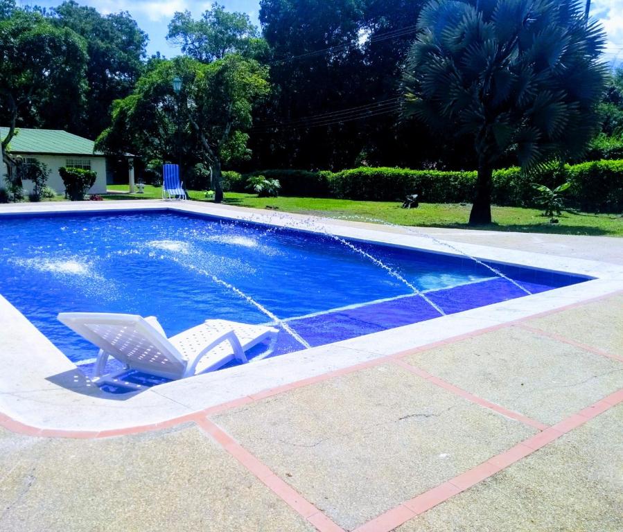 a swimming pool with two lawn chairs and a swimming poolvisor at Finca Hotel La Playa Villeta in Villeta