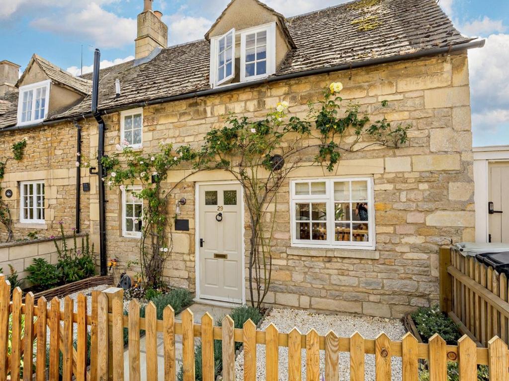 a stone house with a white door and a fence at 1 Bed in Stamford oc-92406 in Ketton