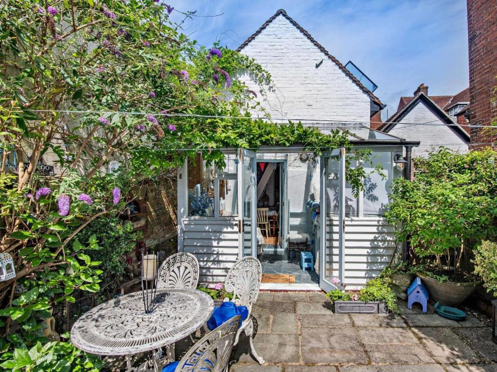 a patio with a table and chairs in front of a house at 1 Bed in Lymington oc-94751 in Lymington
