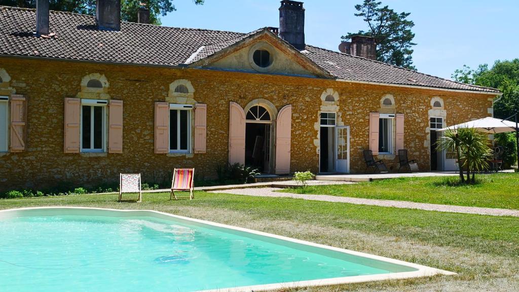 a house with a swimming pool in front of it at La Belle Chartreuse in Manciet