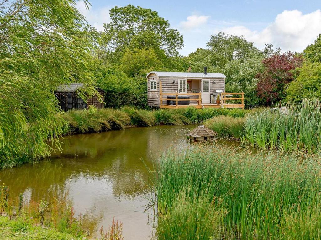 a caravan in a garden next to a river at 1 Bed in Aylesbury oc-76403 in Ludgershall