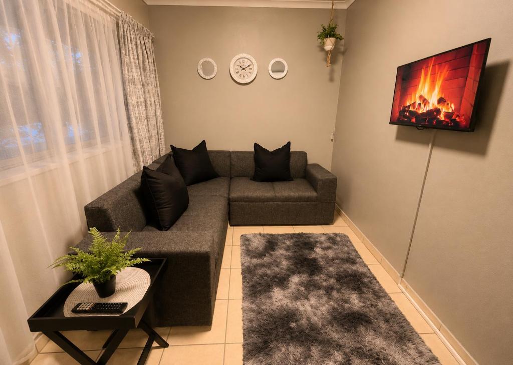 a living room with a couch and a fireplace at Zhantique Guest House 2- Unit 11 in Boksburg