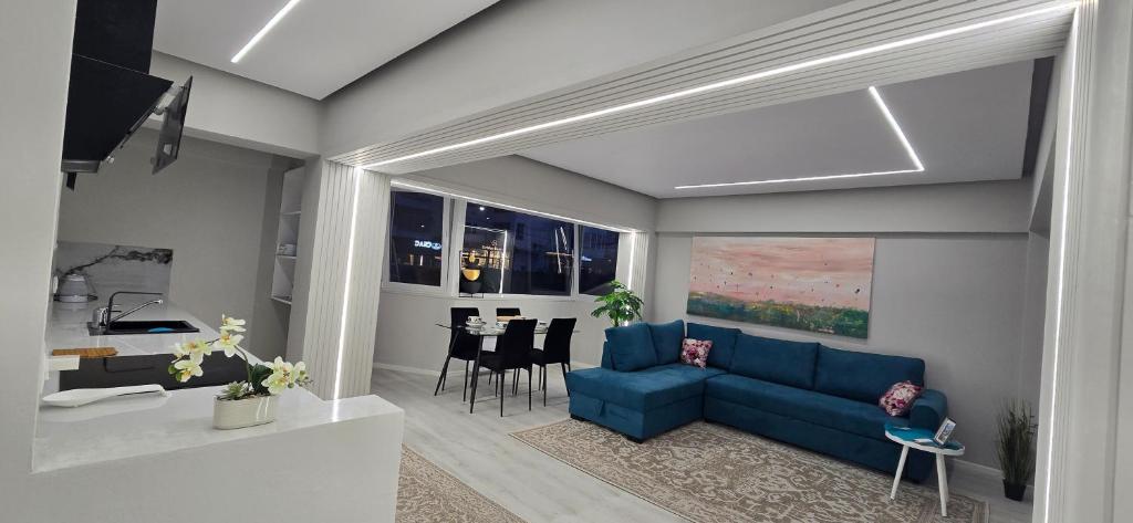a living room with a blue couch and a table at Promenade Apartment ,Sea view in Durrës