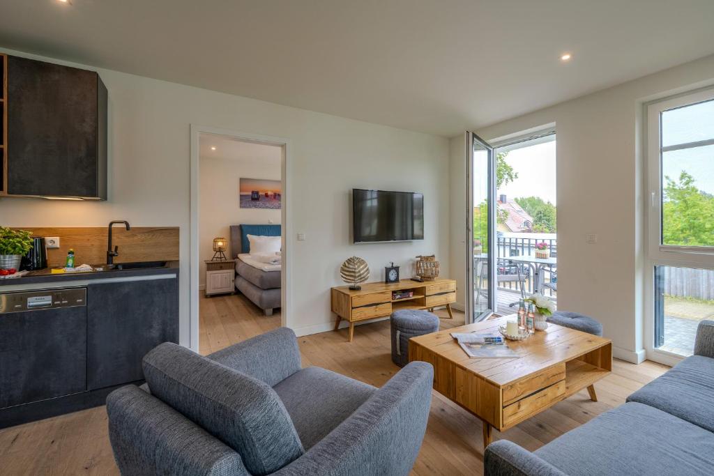 a living room with two couches and a table at Strandhaus Zingst Apartment 11 in Zingst