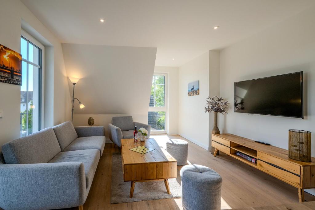 a living room with a couch and a tv at Strandhaus Zingst Apartment 16 in Zingst