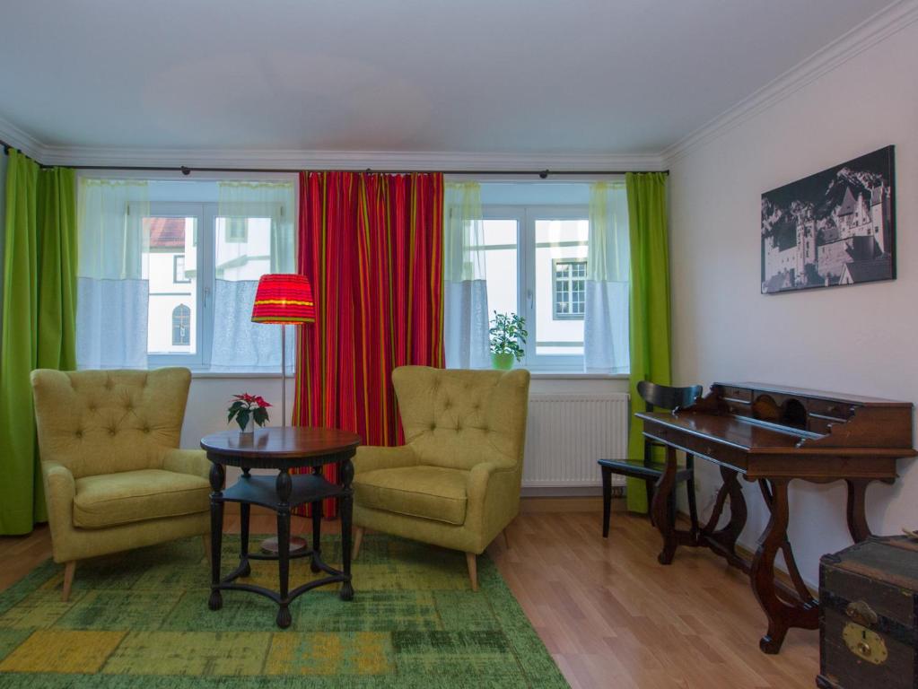 sala de estar con 2 sillas y mesa en Altstadt Ferienwohnung Guade Zeit en Füssen