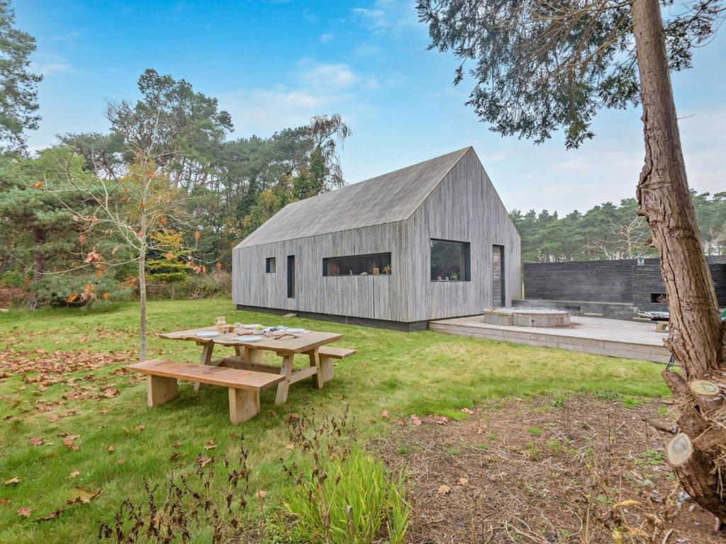 a wooden barn with a picnic table in a yard at 2 Bed in Lymington oc-95021 in Brockenhurst